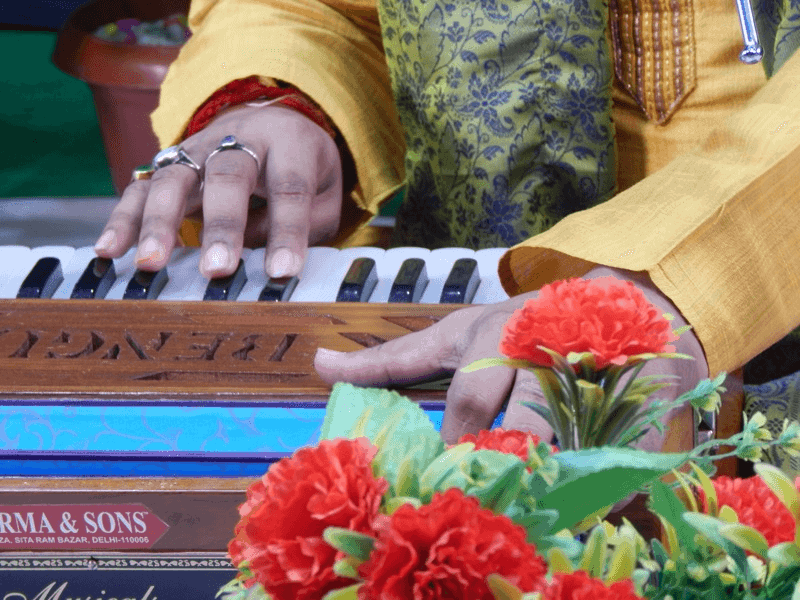 Kirtan is a ceremonial gathering where devotees sing sacred hymns, sometimes accompanied by instruments like the harmonium.