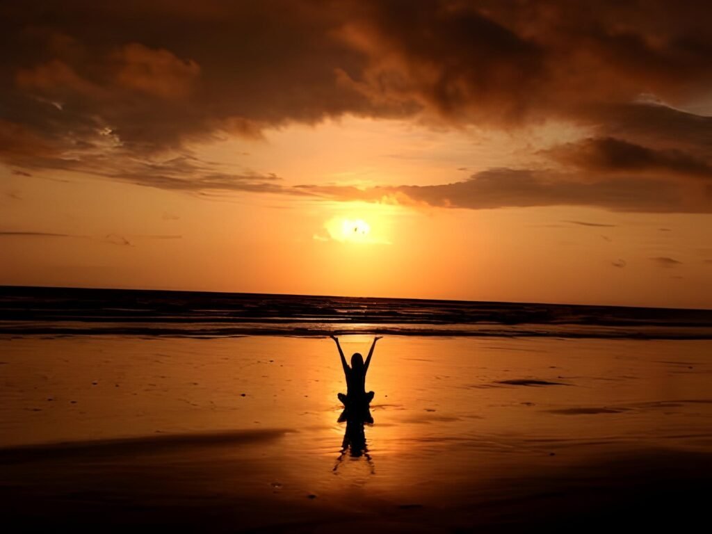 girl standing on a beach during a sunset